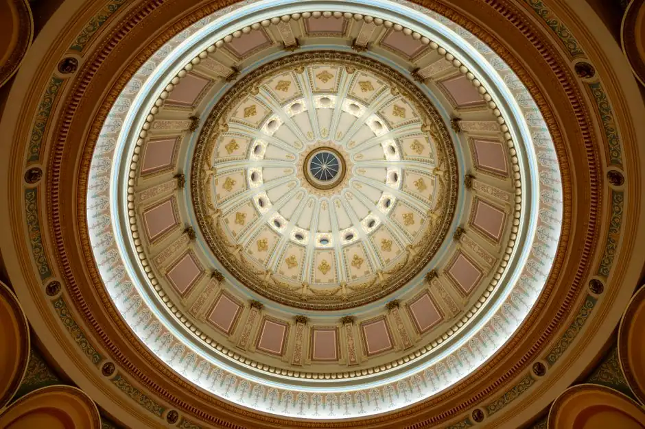 Intricate dome ceiling with ornate architectural details and lighting, viewed from below.